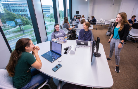 Emily Dux Speltz, a Ph.D. candidate and co-instructor of "Artificial Intelligence and Writing," talks with a group of students as they work on a prompting technique in the Student Innovation Center in September, 2023. Photo by Christopher Gannon/Iowa State