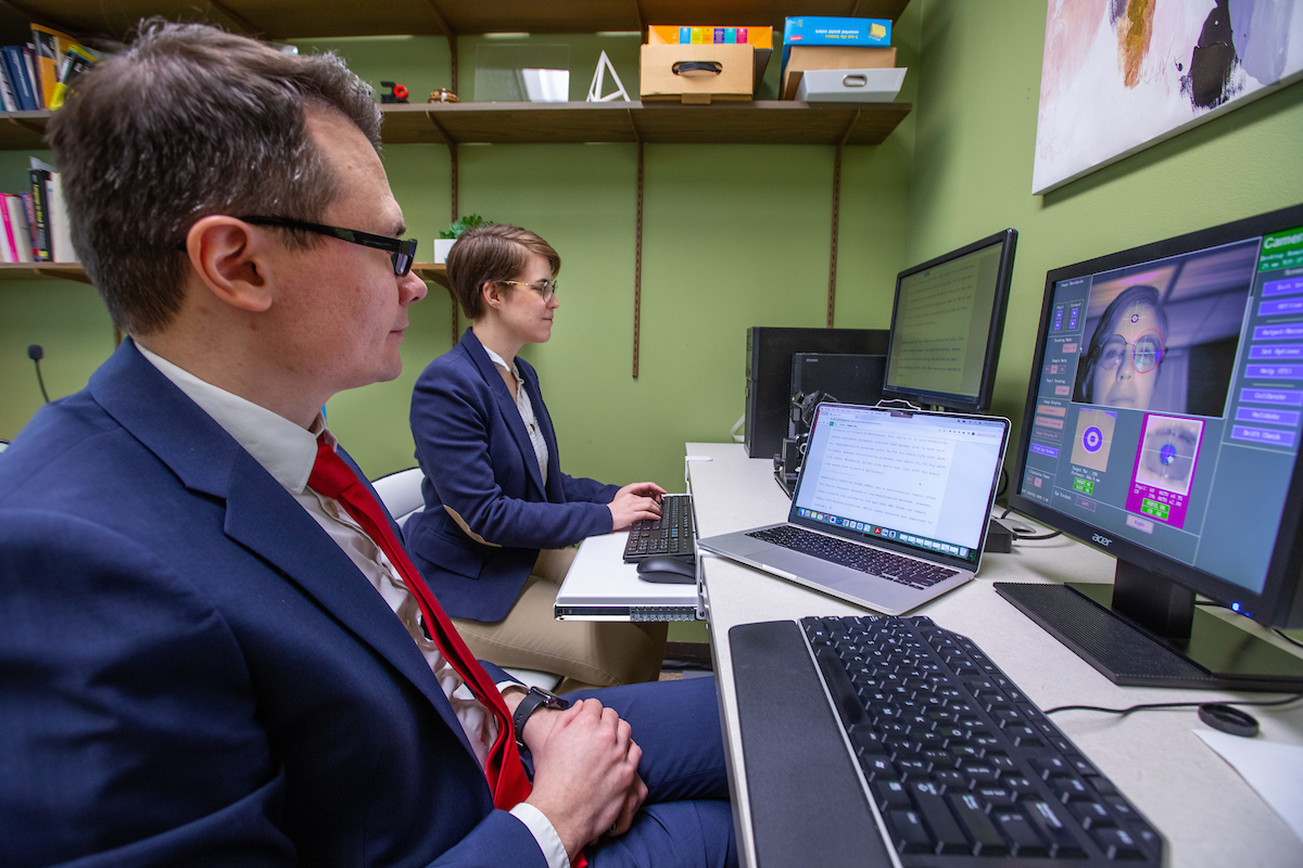 Associate professor Evgeny Chukharev, left, and Wren Bouwman, Ph.D. student in Applied Linguistics and Technology, use an eye tracking system as part of their development of an intelligent tutoring system inside Ross Hall. Photo by Christopher Gannon/Iowa