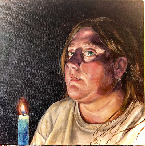 A portrait of a young woman's face bathed in candlelight