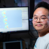 Kun Luo at a computer displaying an atomic model related to material studies of diamonds.
