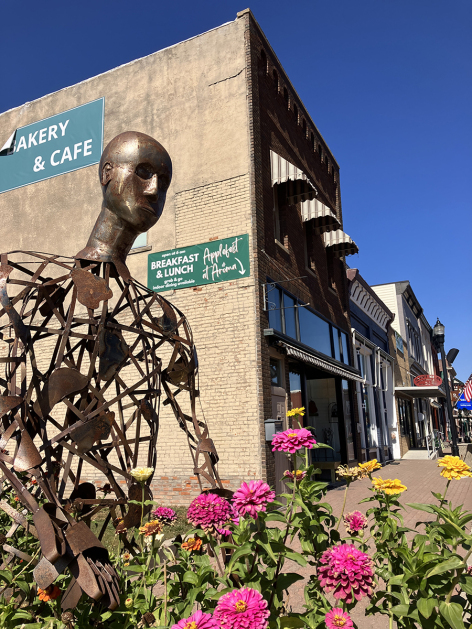 Public art and flowers grace Walker Street in downtown Woodbine, Oct. 2023. Woodbine was one of three cities to receive a Great American Main Street Award in 2014. Photo by Rachel Cramer/Iowa State University.