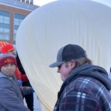 Students inflate a high altitude balloon in a parking lot at Iowa State University