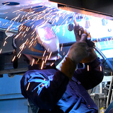 Person welding with sparks flying from welder