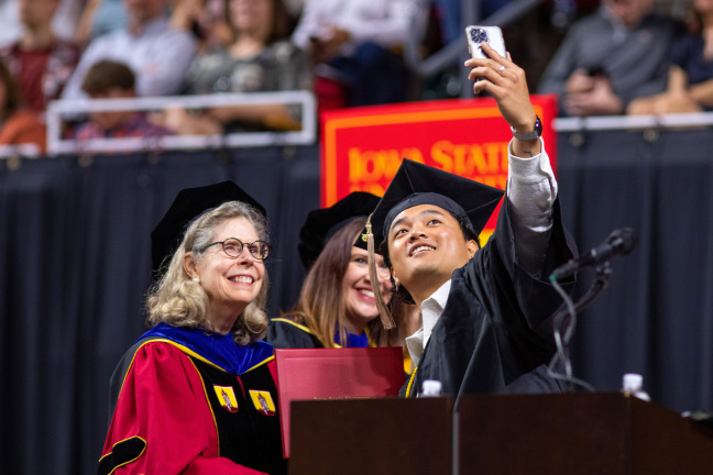 Student takes a selfie with President Wintersteen at commencement spring 2023